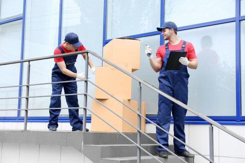Staff wearing PPE while handling boxes during a man with a van move