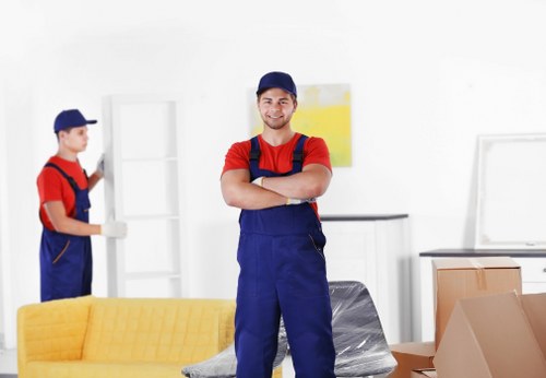 Professional movers handling furniture and boxes near a Mayfair property entrance